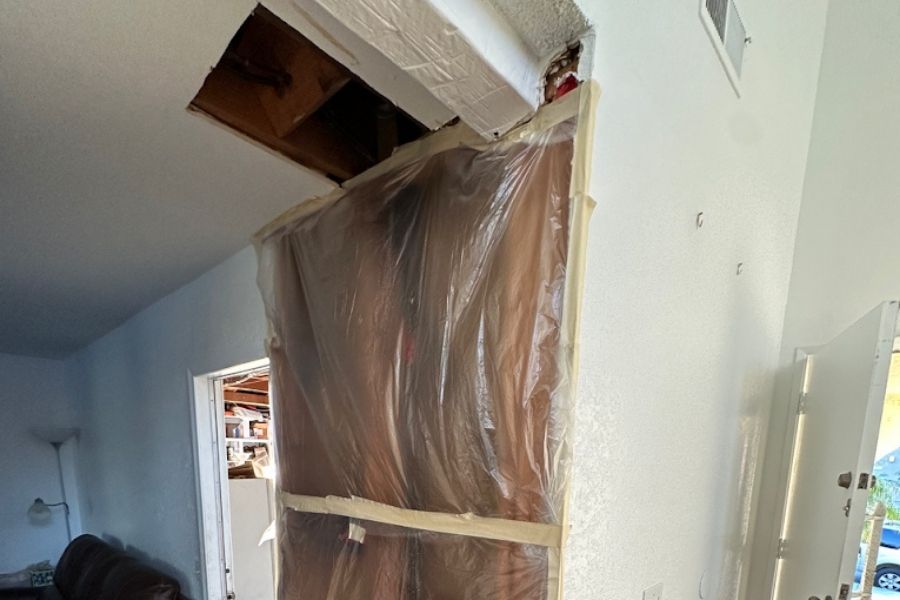 Drywall removal and containment setup during water damage restoration after a burst pipe