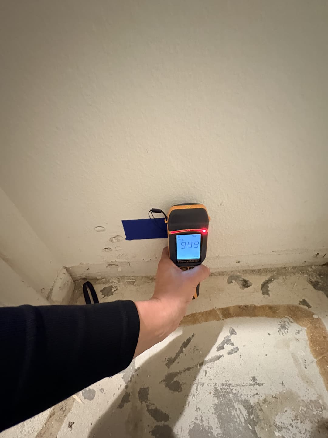 Moisture meter showing high reading on kitchen wall near shared plumbing in Anaheim