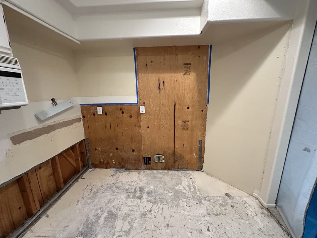 Exposed insulation and wall cavity after material removal during water damage restoration in Anaheim